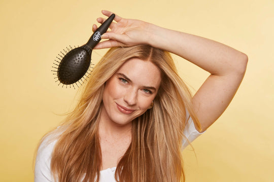 Photo of a blonde woman holding a Wet Brush Easy Blow Out Brush