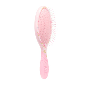 Pink hairbrush with floral design on a white background