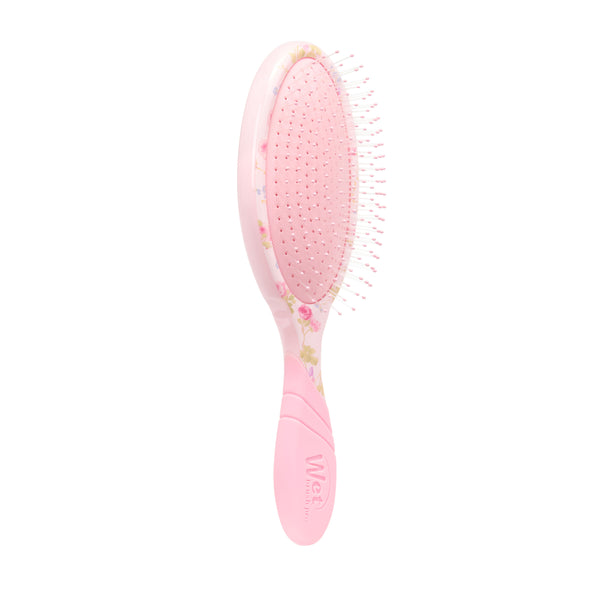 Pink hairbrush with floral design on a white background