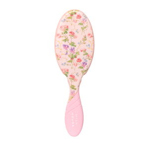Pink hairbrush with floral pattern on a white background