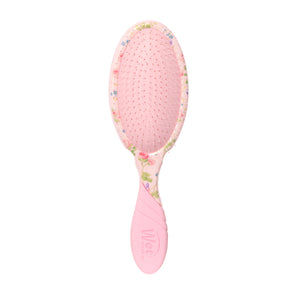 Pink hairbrush with floral pattern on a white background